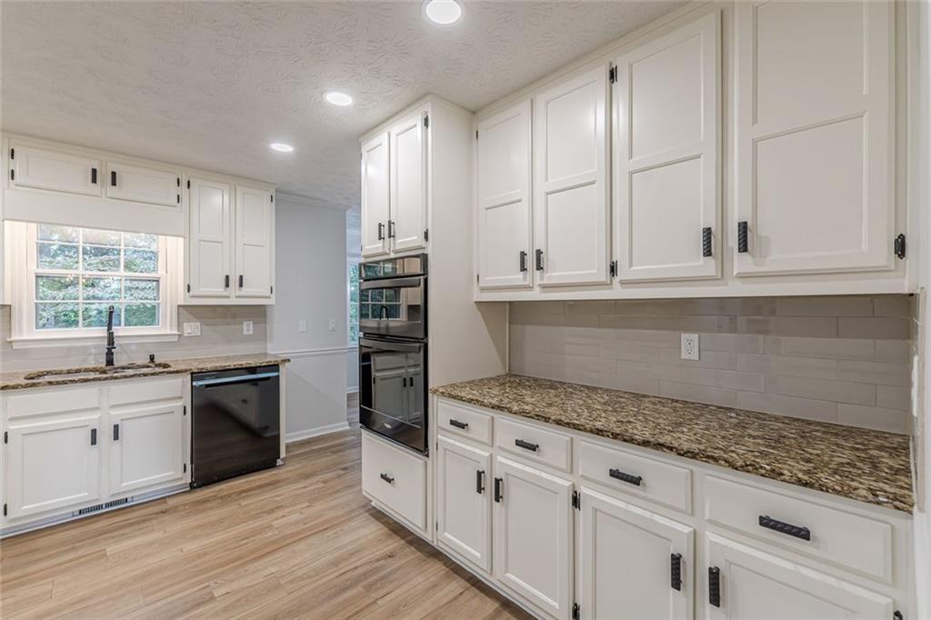 2011 Old Peachtree Road Northwest Duluth, GA 30097 - Photo 3 of 37 a kitchen with granite countertop white cabinets and appliances
