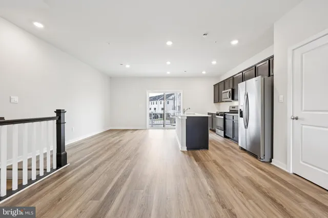 a kitchen with stainless steel appliances a refrigerator and wooden floor