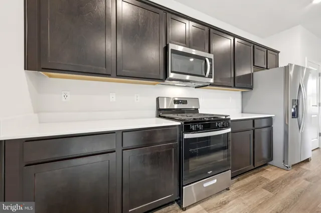 a kitchen with stainless steel appliances and wooden cabinets