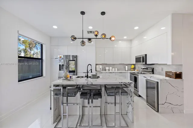 a kitchen that has a lot of cabinets in it and appliances
