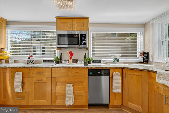 a kitchen with stainless steel appliances granite countertop a sink and a microwave