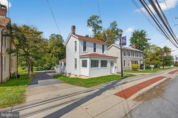 a front view of a house with a yard and trees