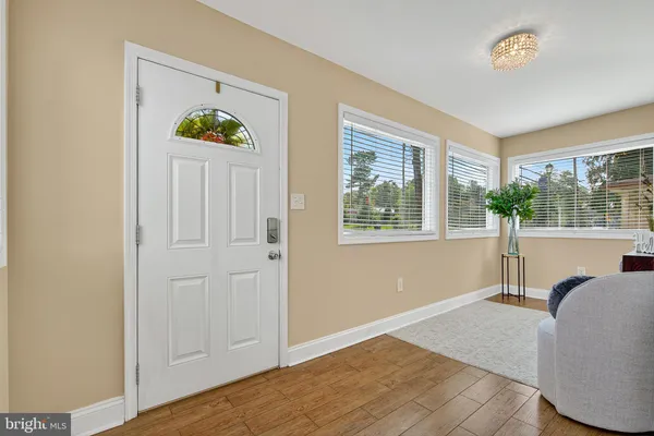 a view of a bedroom with wooden floor and windows
