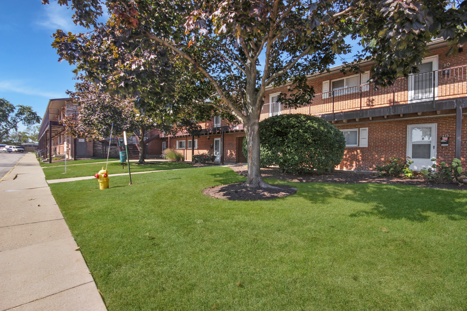 1900 Knights Bridge Drive, Unit 2B Mount Prospect, IL 60056 - Photo 15 of 16 a view of a house with a big yard and large trees