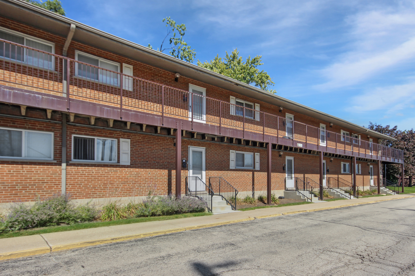 1900 Knights Bridge Drive, Unit 2B Mount Prospect, IL 60056 - Photo 2 of 16 a front view of a building with a garden