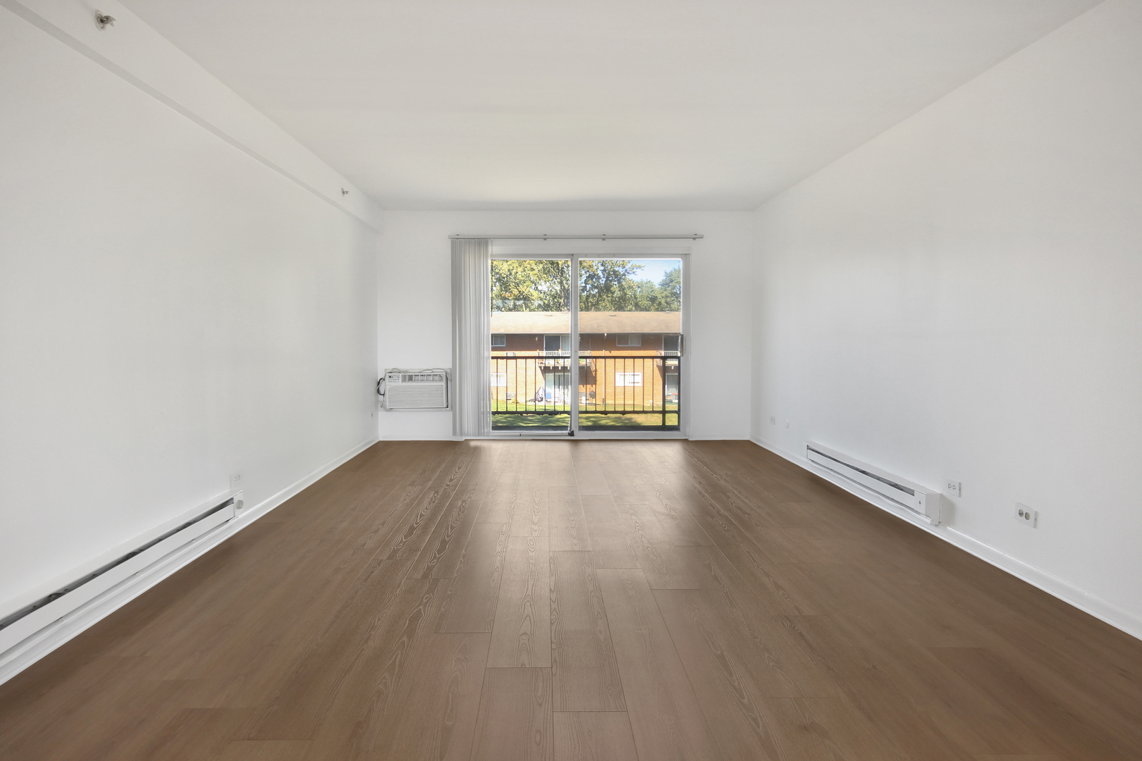 1900 Knights Bridge Drive, Unit 2B Mount Prospect, IL 60056 - Photo 9 of 16 an empty room with wooden floor and windows
