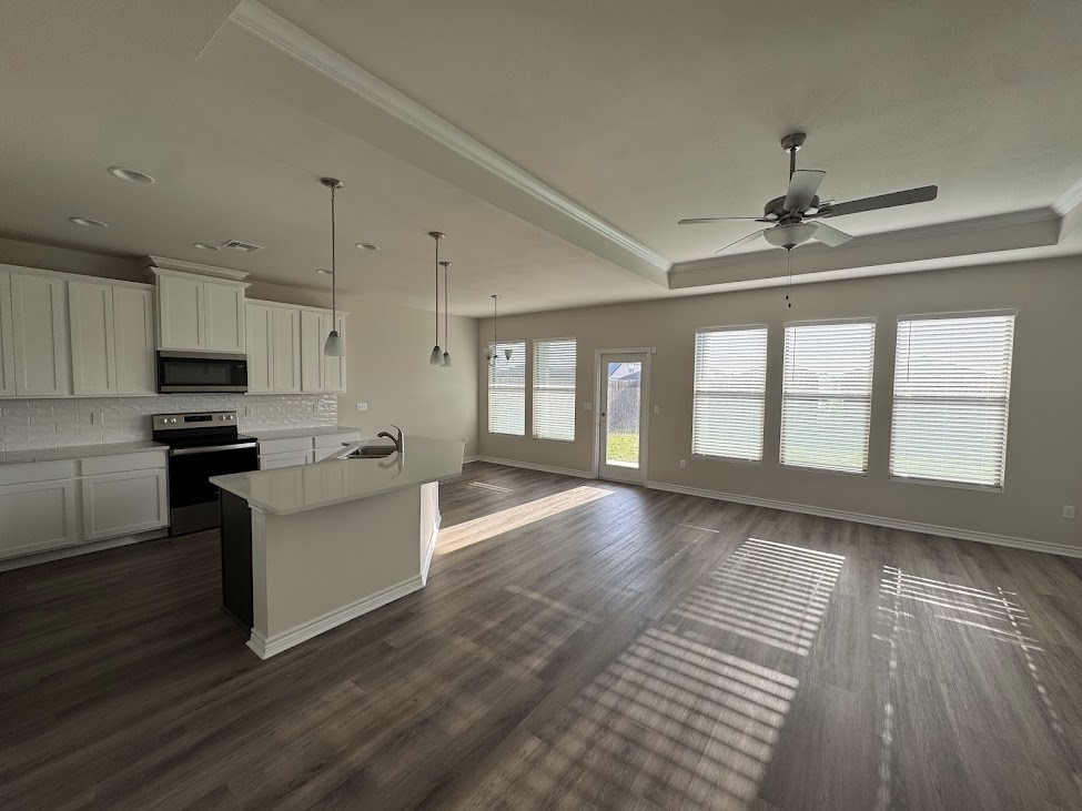 2658 Westeros Street Corpus Christi, TX 78415 - Photo 3 of 13 a kitchen with granite countertop a stove top oven a sink dishwasher a dining table and chairs with wooden floor