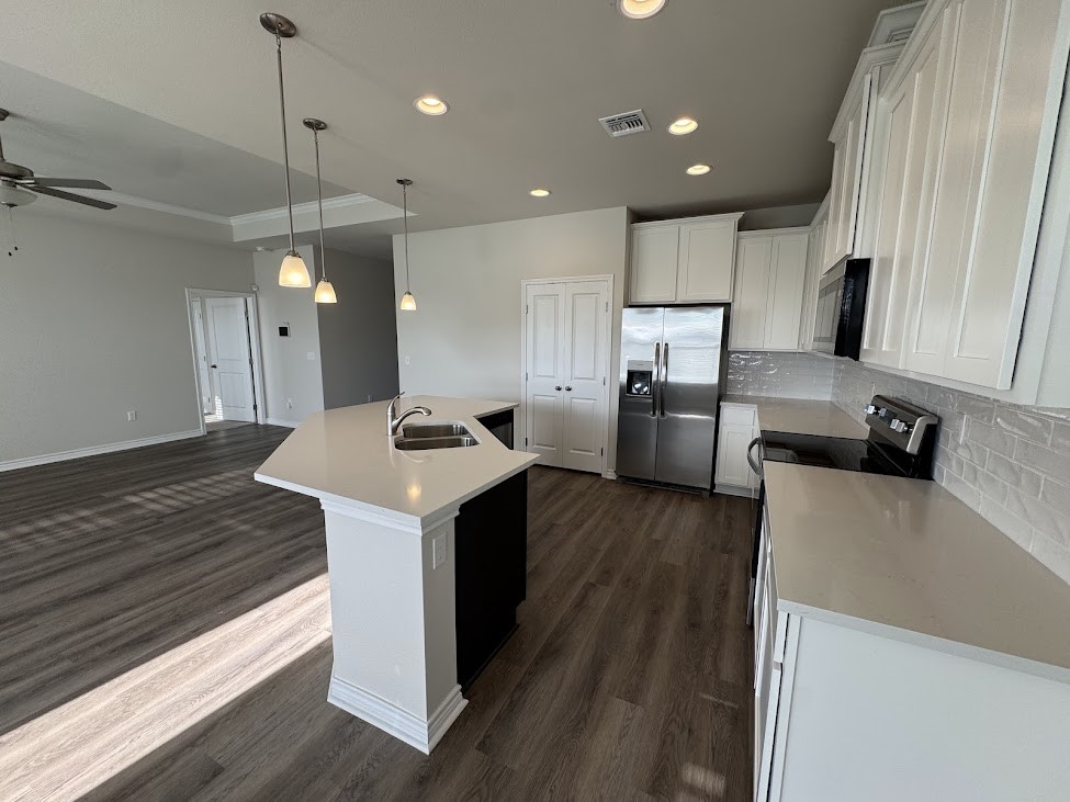 2658 Westeros Street Corpus Christi, TX 78415 - Photo 4 of 13 a kitchen with refrigerator and microwave