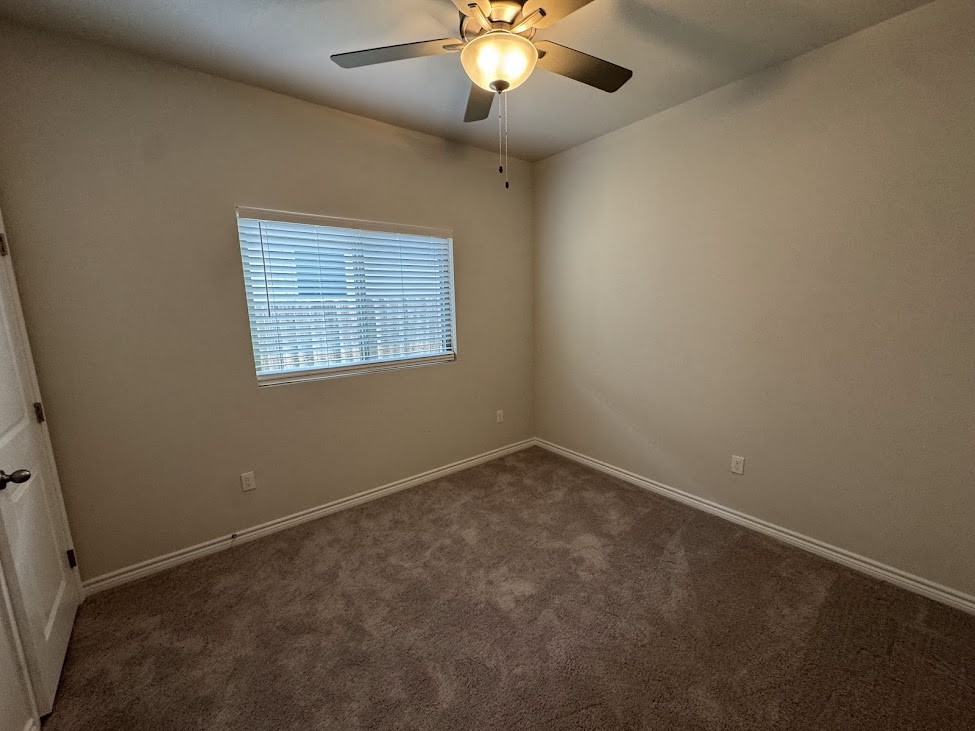 2658 Westeros Street Corpus Christi, TX 78415 - Photo 7 of 13 an empty room with a chandelier fan and windows