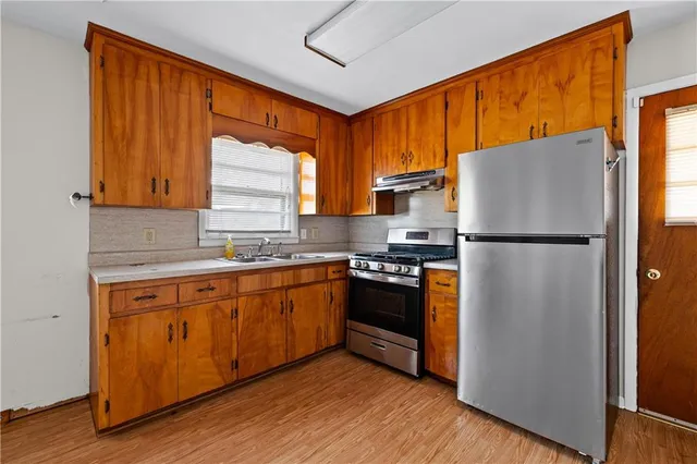 a kitchen with stainless steel appliances granite countertop a refrigerator stove and sink