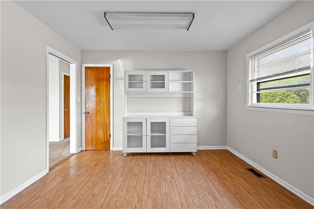 104 Denham Street Thomaston, GA 30286 - Photo 12 of 26 an empty room with wooden floor and windows
