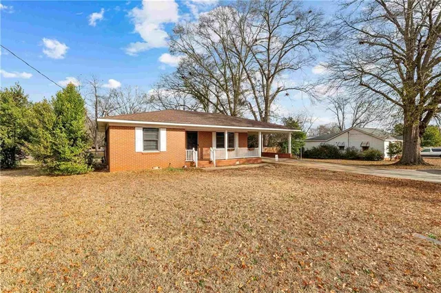 a front view of house with yard and trees around