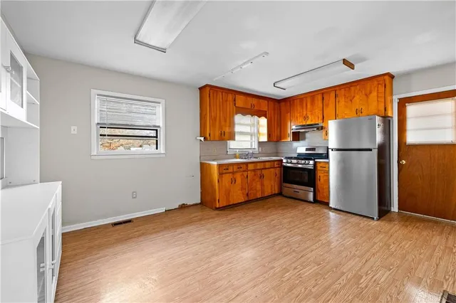 a kitchen with a refrigerator a stove top oven a sink dishwasher and a refrigerator