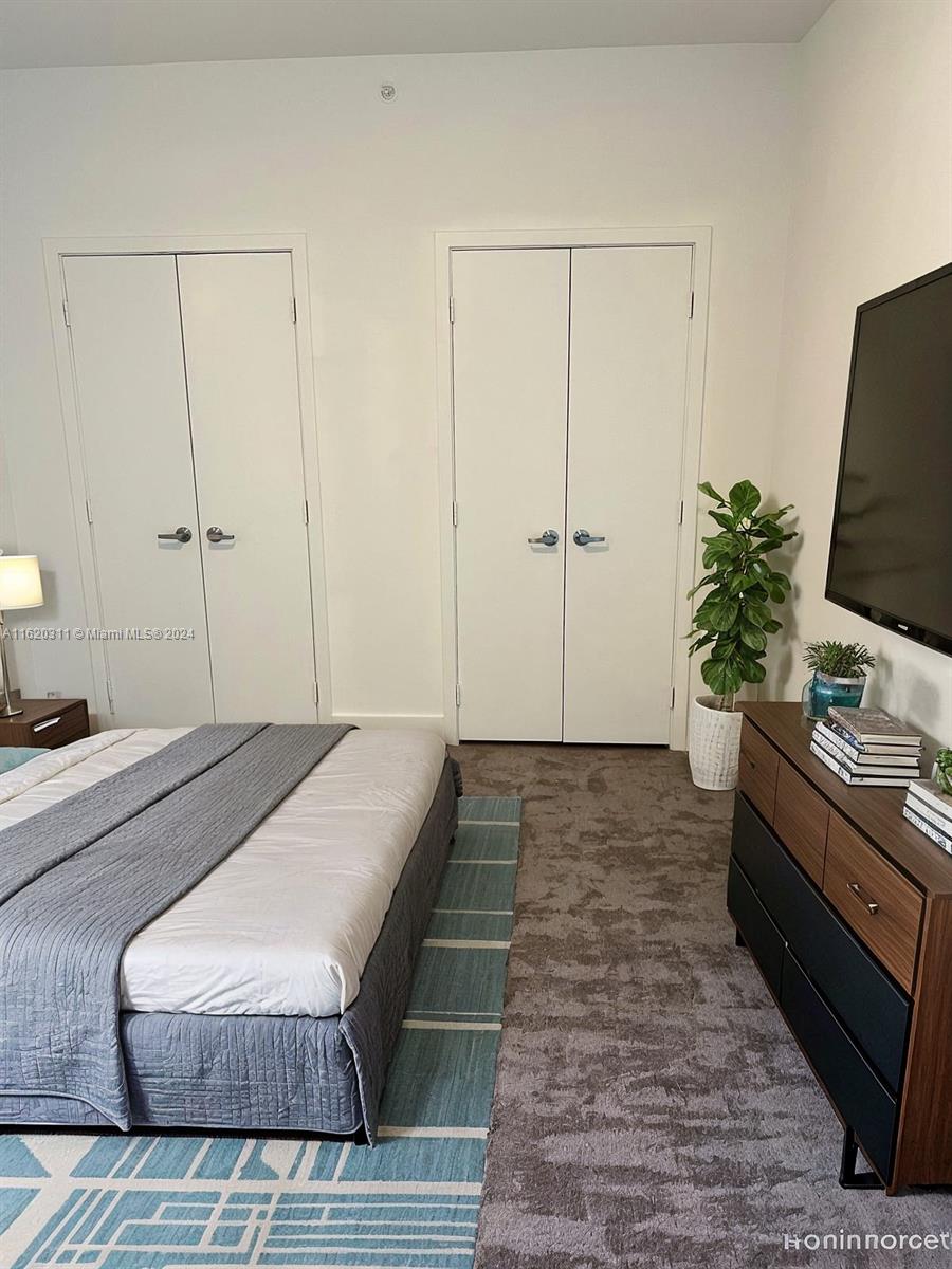 888 Biscayne Boulevard, Unit 509 Miami, FL 33132 - Photo 5 of 32 a bedroom with a bed and a flat screen tv