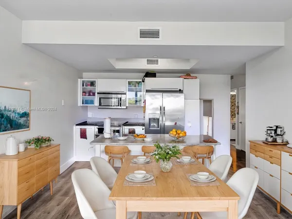 a dining room with furniture a chandelier and kitchen view