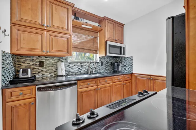 a kitchen with stainless steel appliances granite countertop a sink and cabinets