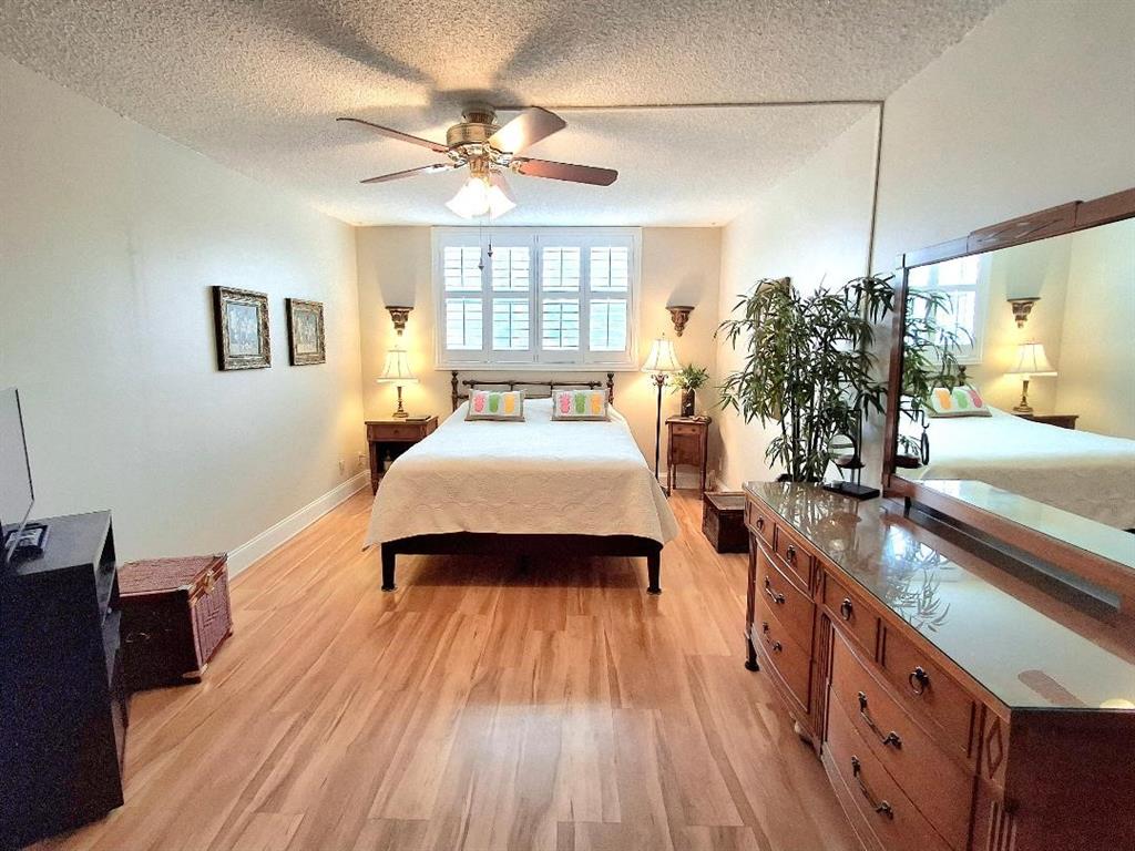 1421 South Ocean Boulevard, Unit 206 Pompano Beach, FL 33062 - Photo 13 of 40 a spacious bedroom with a large bed a chandelier and windows