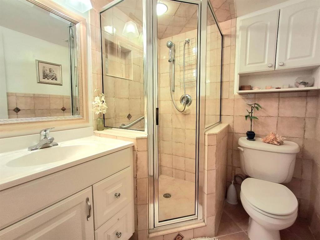 1421 South Ocean Boulevard, Unit 206 Pompano Beach, FL 33062 - Photo 20 of 40 a bathroom with a granite countertop toilet a sink and a mirror