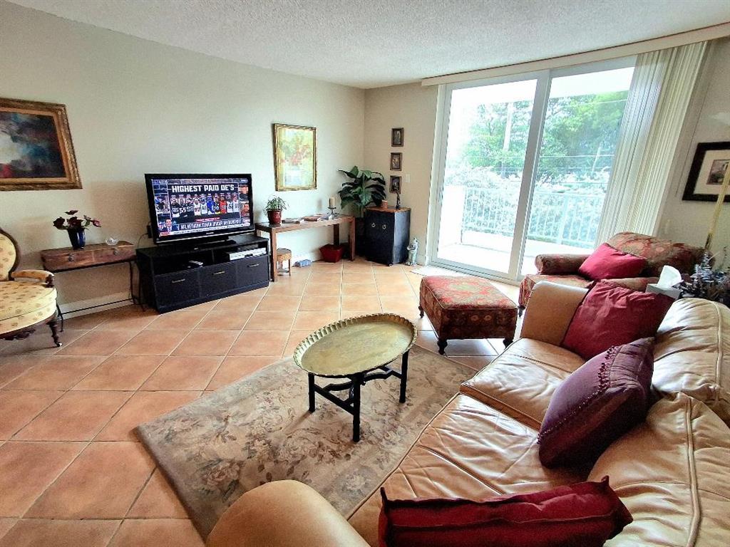 1421 South Ocean Boulevard, Unit 206 Pompano Beach, FL 33062 - Photo 4 of 40 a living room with furniture and a flat screen tv
