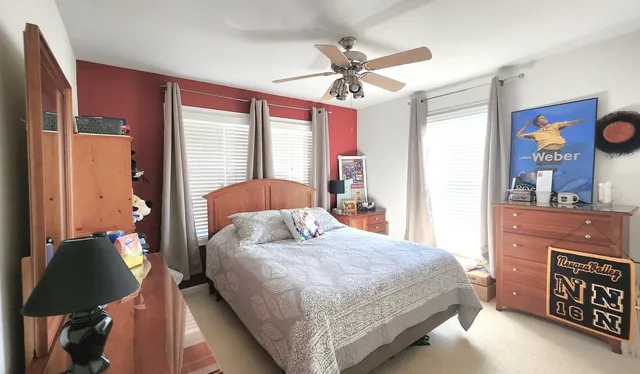 a bedroom with a bed dresser and wooden floor