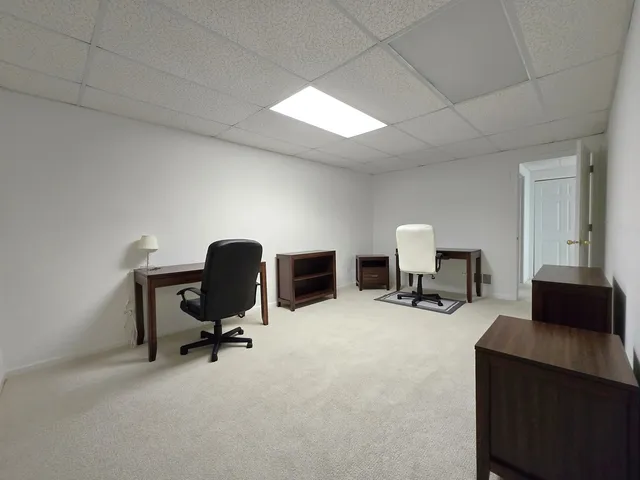 a view of a workspace with furniture and a ceiling fan