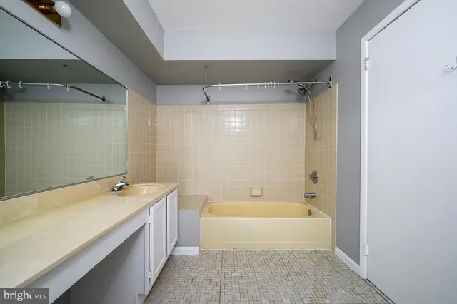 a spacious bathroom with a granite countertop sink a toilet a shower and a mirror