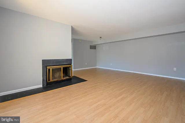 a view of an empty room with a fireplace and a window
