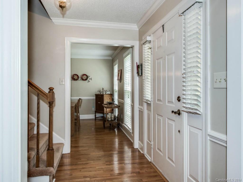 7301 Alexander Road Charlotte, NC 28270 - Photo 4 of 24 a view of a hallway with wooden floor and a living room