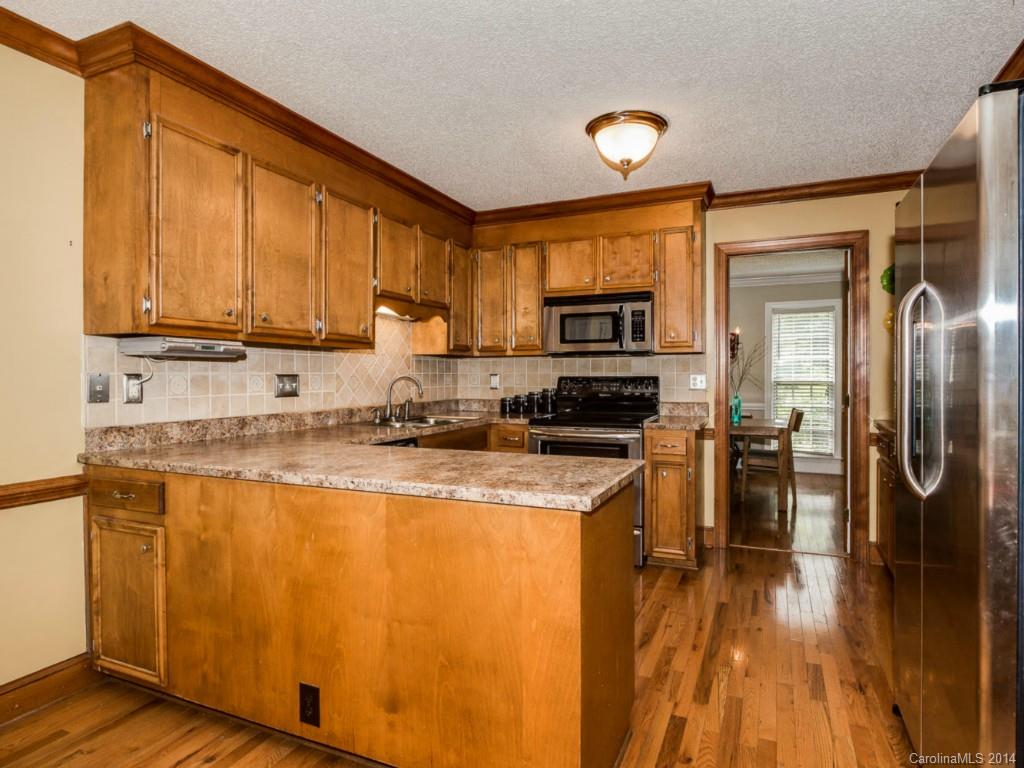 7301 Alexander Road Charlotte, NC 28270 - Photo 8 of 24 a kitchen with stainless steel appliances granite countertop a refrigerator a stove top oven a sink and dishwasher