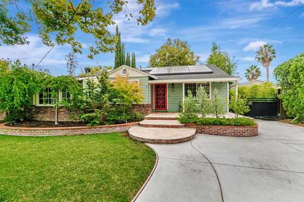a front view of a house with a yard and fountain