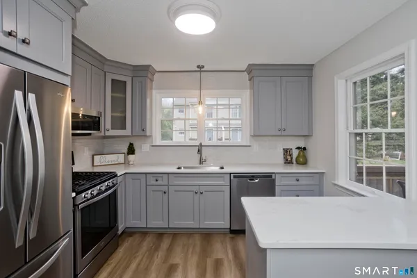 a kitchen with a sink a window stainless steel appliances and windows