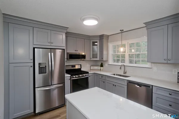 a kitchen with a refrigerator a sink and wooden cabinets