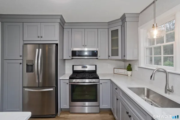 a kitchen with stainless steel appliances a refrigerator stove and sink
