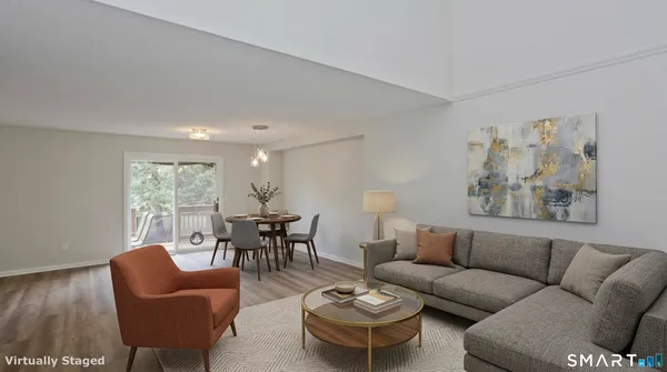 a living room with furniture kitchen view and a window