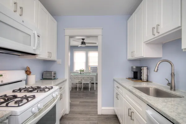 a kitchen with granite countertop white cabinets and sink