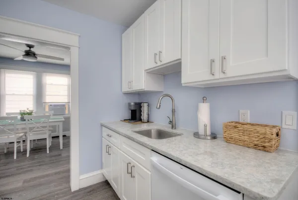 a kitchen with granite countertop white cabinets and a sink