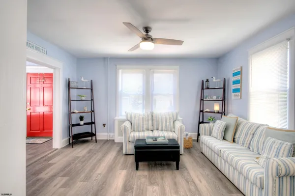 a living room with furniture wooden floor and a window