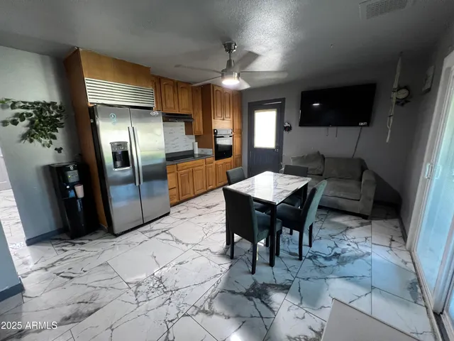 a kitchen with stainless steel appliances kitchen island granite countertop a refrigerator a stove a sink dishwasher and microwave oven