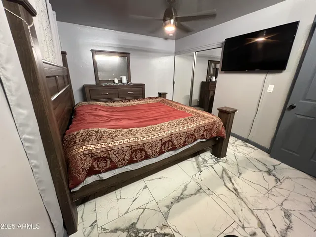 a bedroom with a bed a flat screen tv and a chandelier