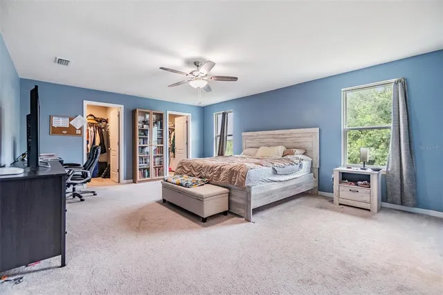 a spacious bedroom with a large bed and a chandelier