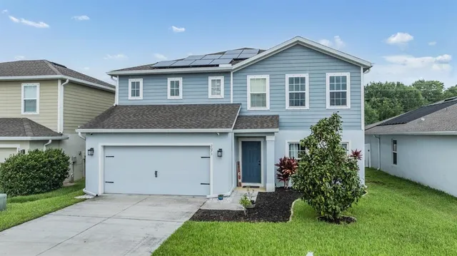 a front view of a house with a garden and plants