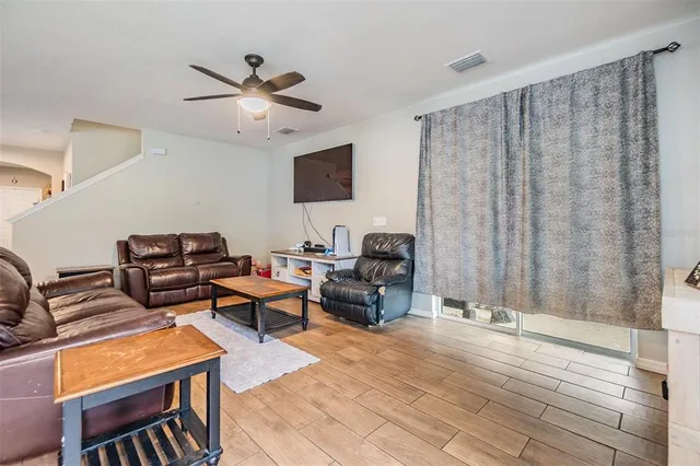a living room with furniture and a ceiling fan