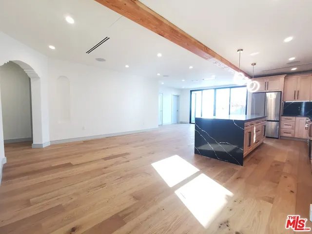 a living room with a couch and a view of kitchen