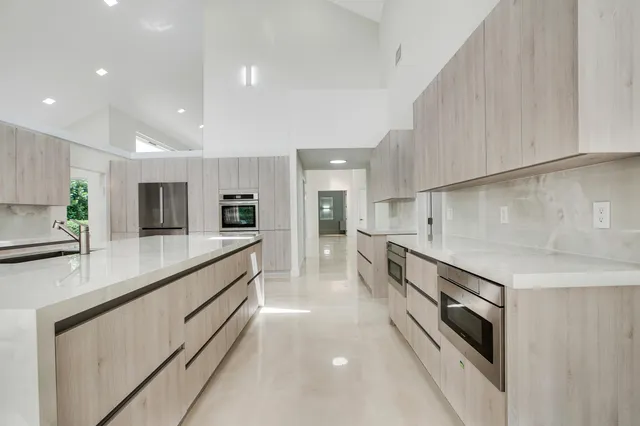 a large kitchen with stainless steel appliances double vanity sink and stove