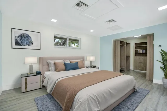 a bedroom with bed and wall painting with wooden floor