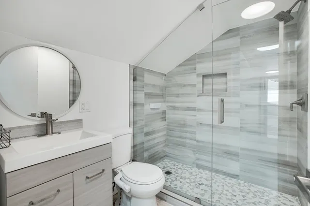 a bathroom with a sink a toilet and shower