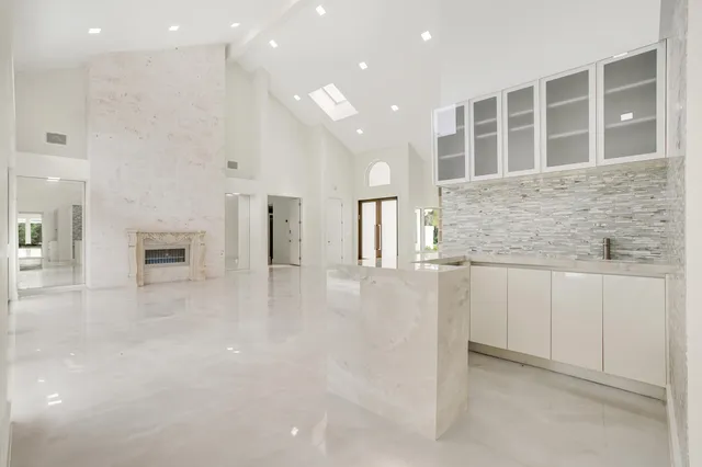 a view of kitchen with granite countertop cabinets and chandelier