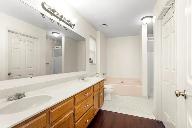 a spacious bathroom with a tub double sink and mirror