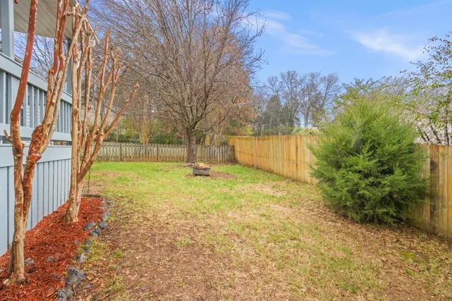 a view of yard with tree and wooden fence