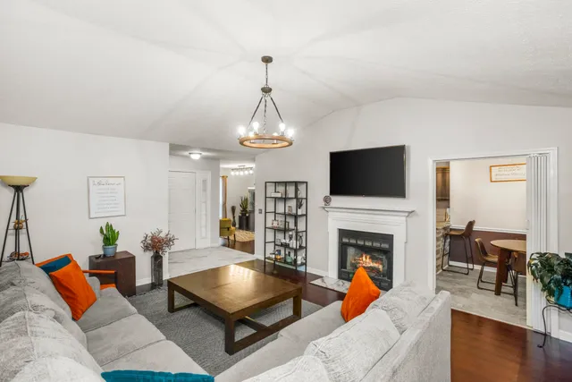 a living room with furniture a flat screen tv and a fireplace